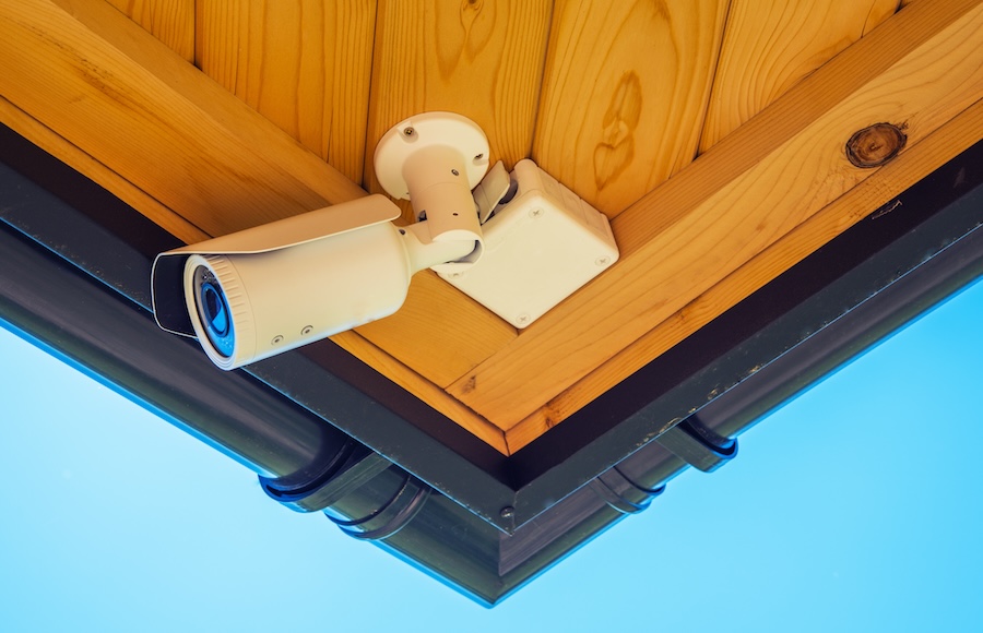 An outdoor security camera installed under a roof.